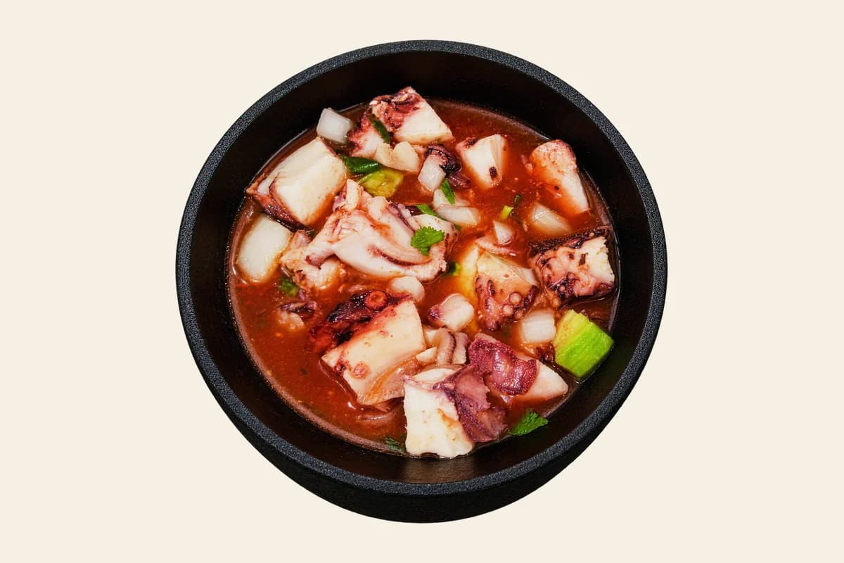 Coctel de pulpo: octopus cocktail in red tomato broth with onion, cilantro and avocado