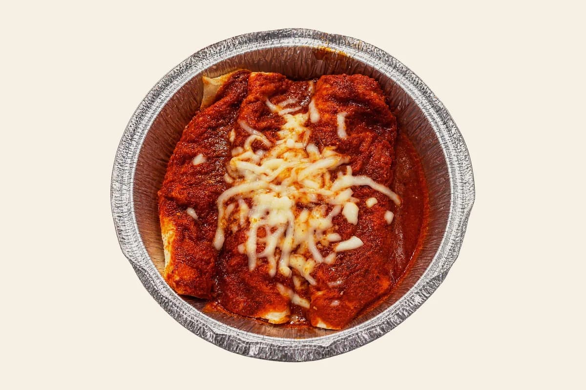 Enchiladas rojas topped with red enchilada sauce and shredded cheese